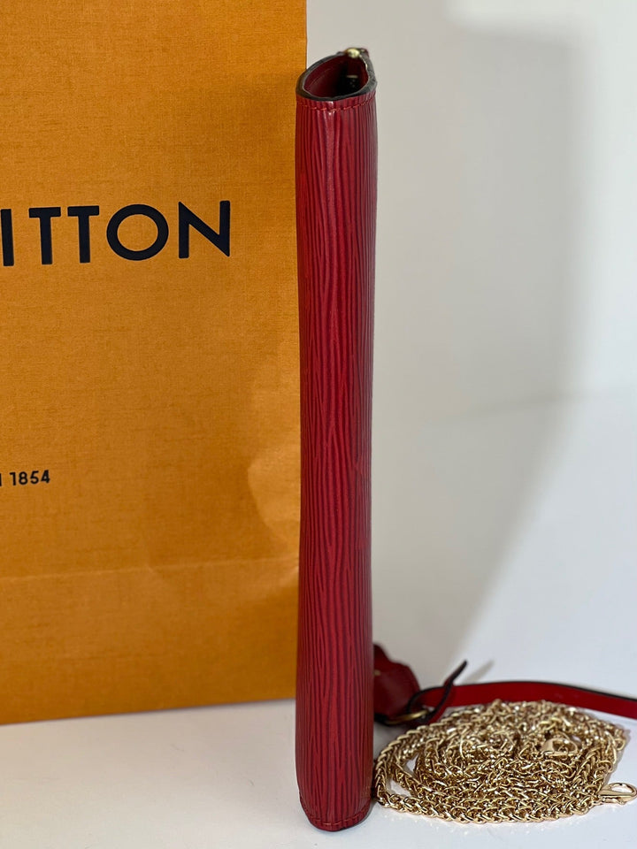 Red handbag with gold chain and 'Louis Vuitton' box in the background