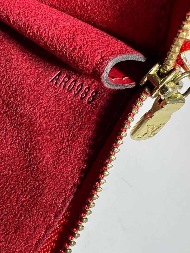 Close-up of a red textured surface with a gold zipper and 'AR0988' branding.