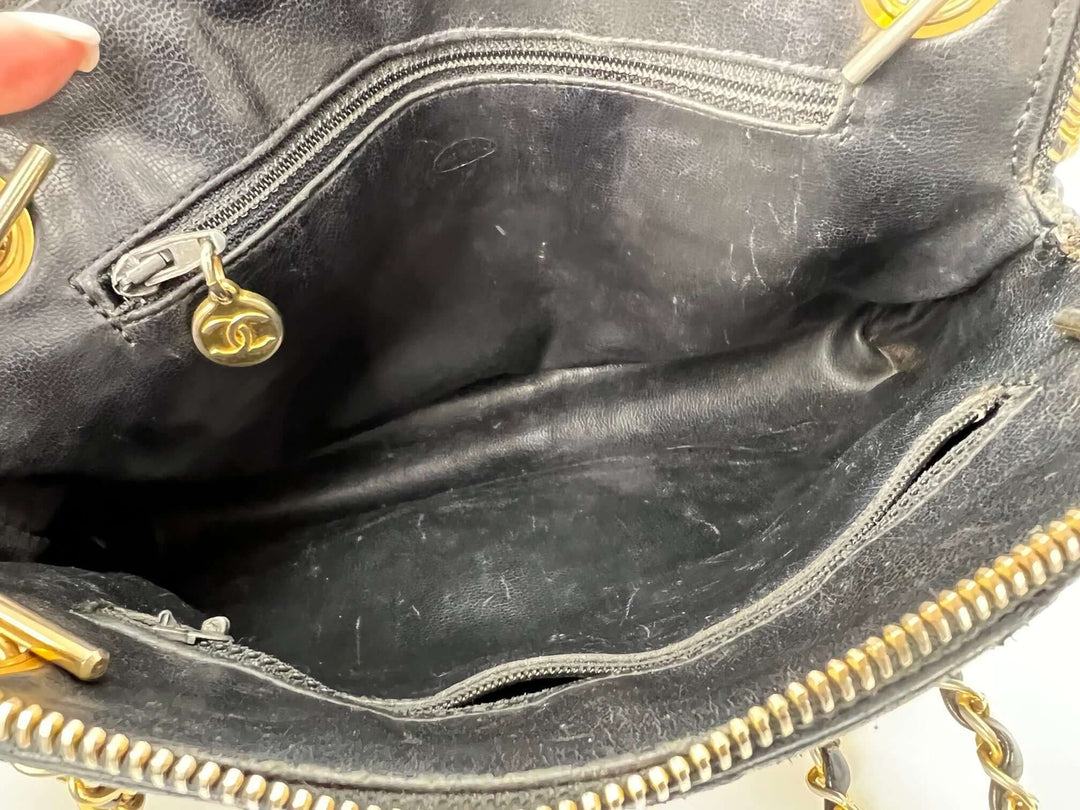 Close-up of a black leather handbag with gold zippers and hardware.