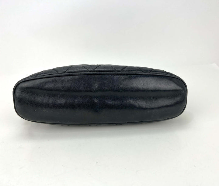 Black quilted handbag on a white background