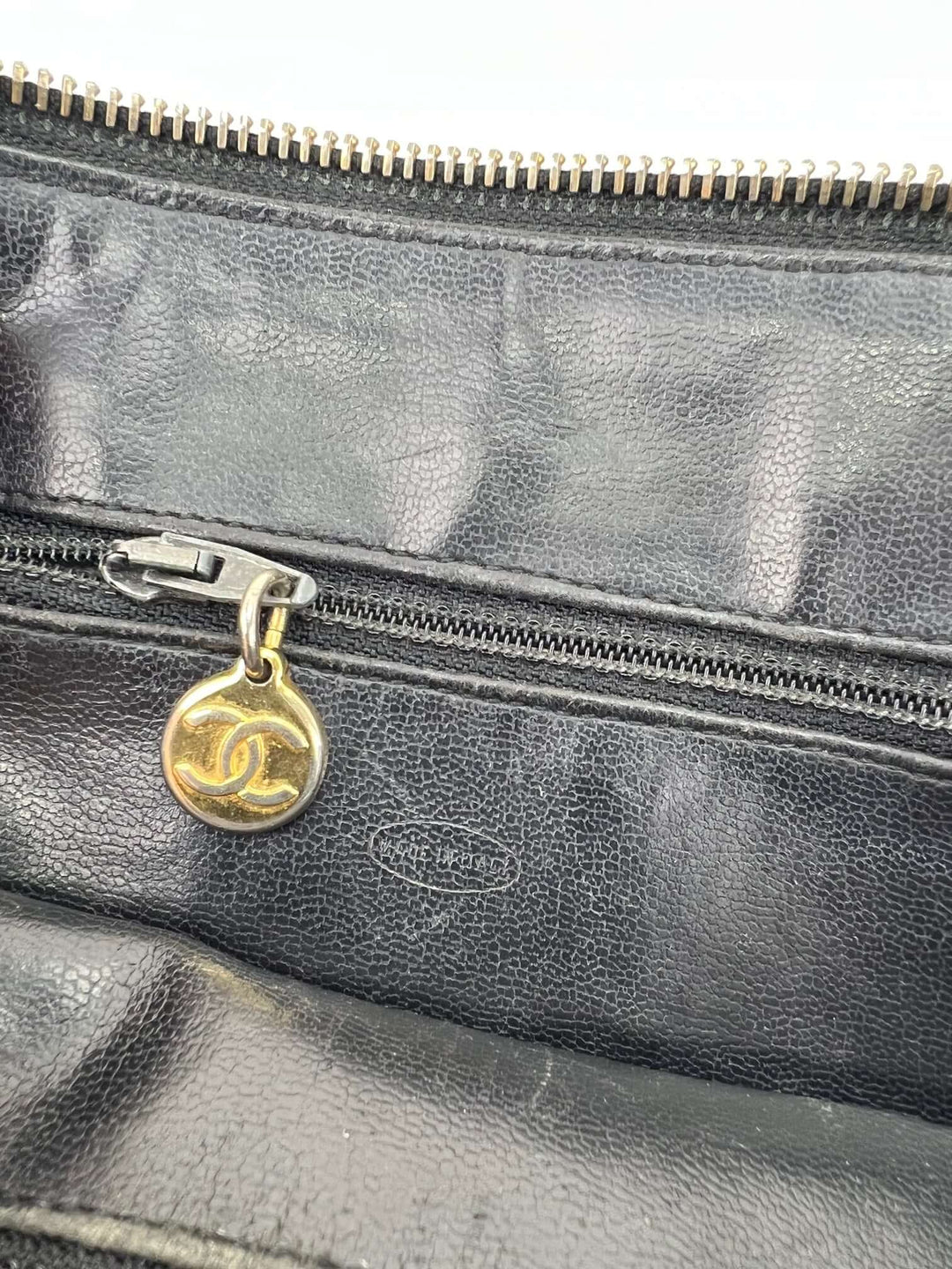 Black leather handbag with gold CC logo charm on a white background