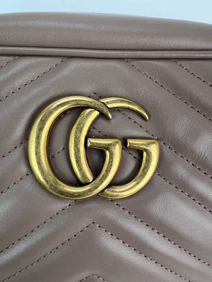 Close-up of a brown leather handbag with a gold Gucci logo.
