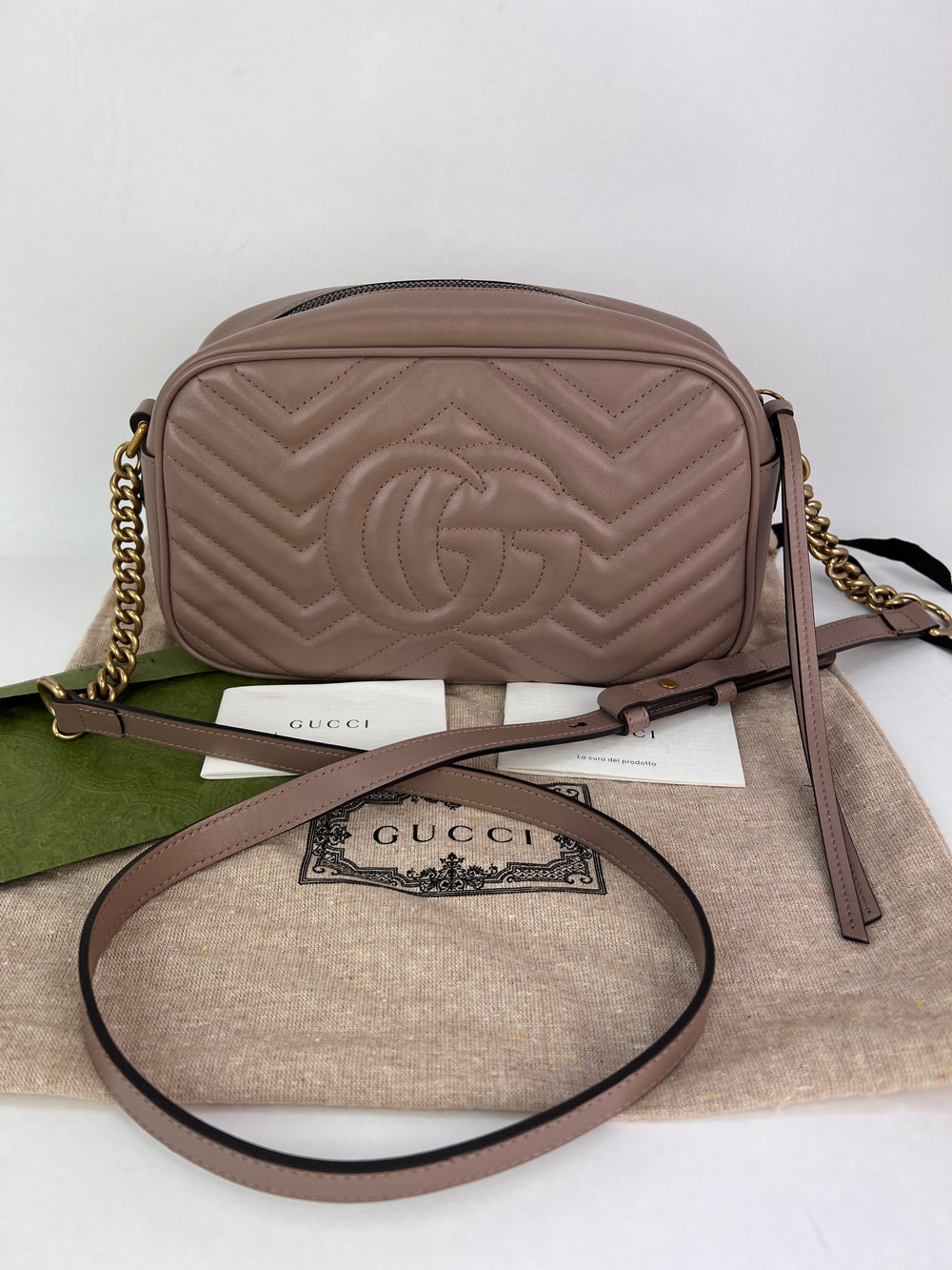 Brown Gucci handbag with gold chain on a white background