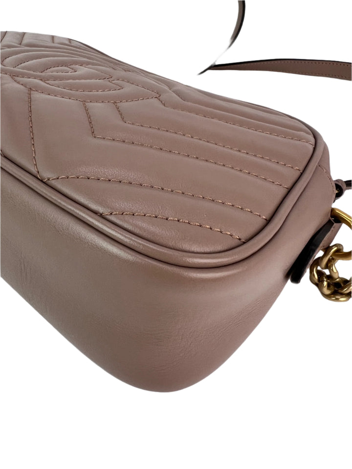 Close-up of a beige handbag with a gold chain detail on a white background