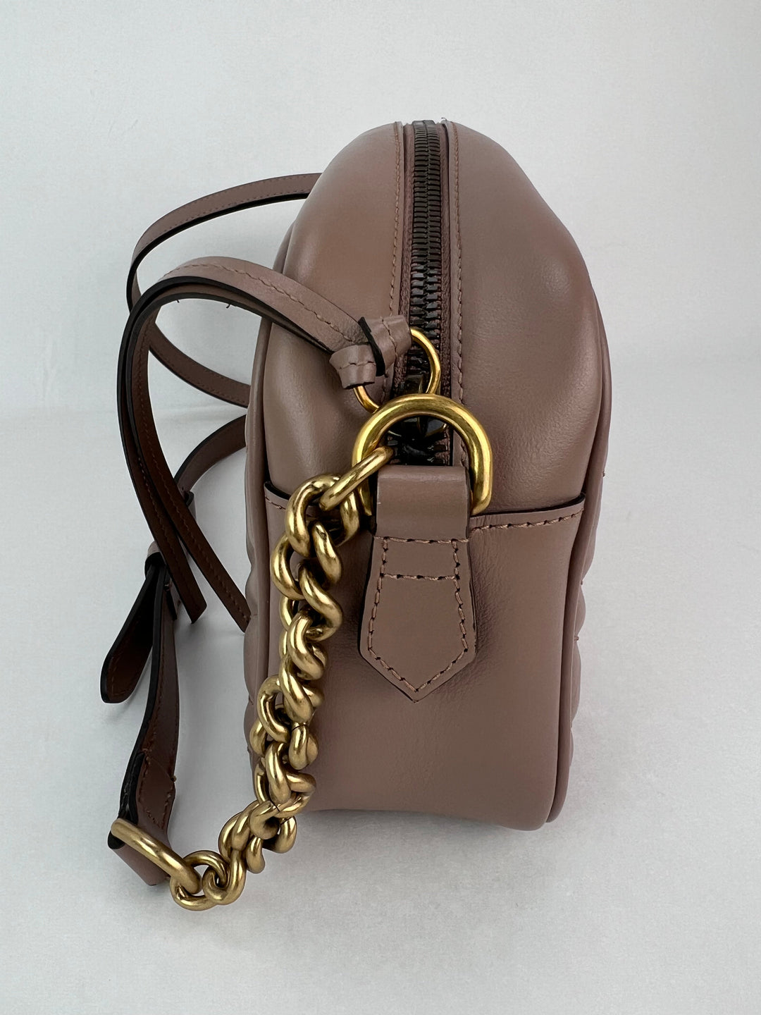 Brown leather backpack with a gold chain on a white background