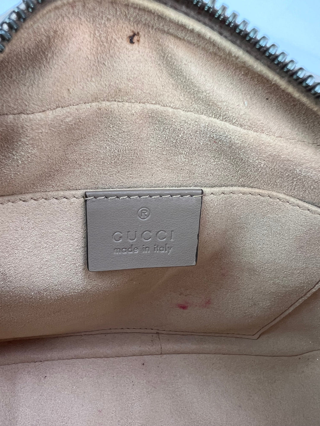 Beige Gucci handbag with visible wear and a brand label.