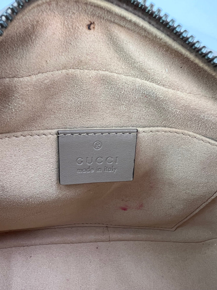 Beige Gucci handbag with visible wear and a brand label.