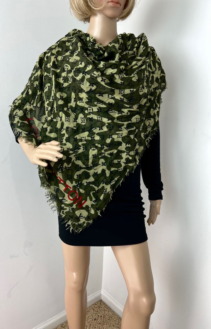 Mannequin wearing a green camouflage-patterned scarf with red accents on a plain background