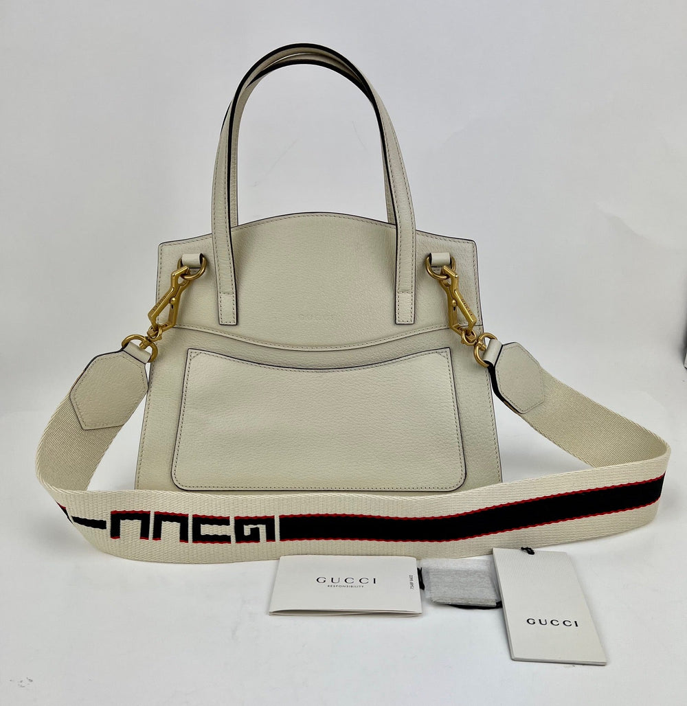 Beige handbag with a Gucci logo strap on a white background