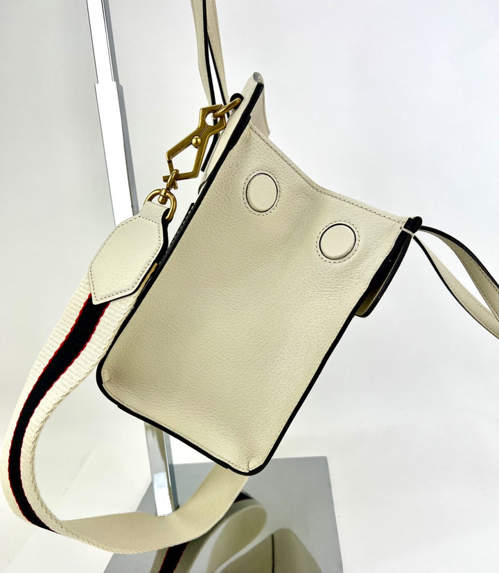 Beige handbag with black accents on a white background