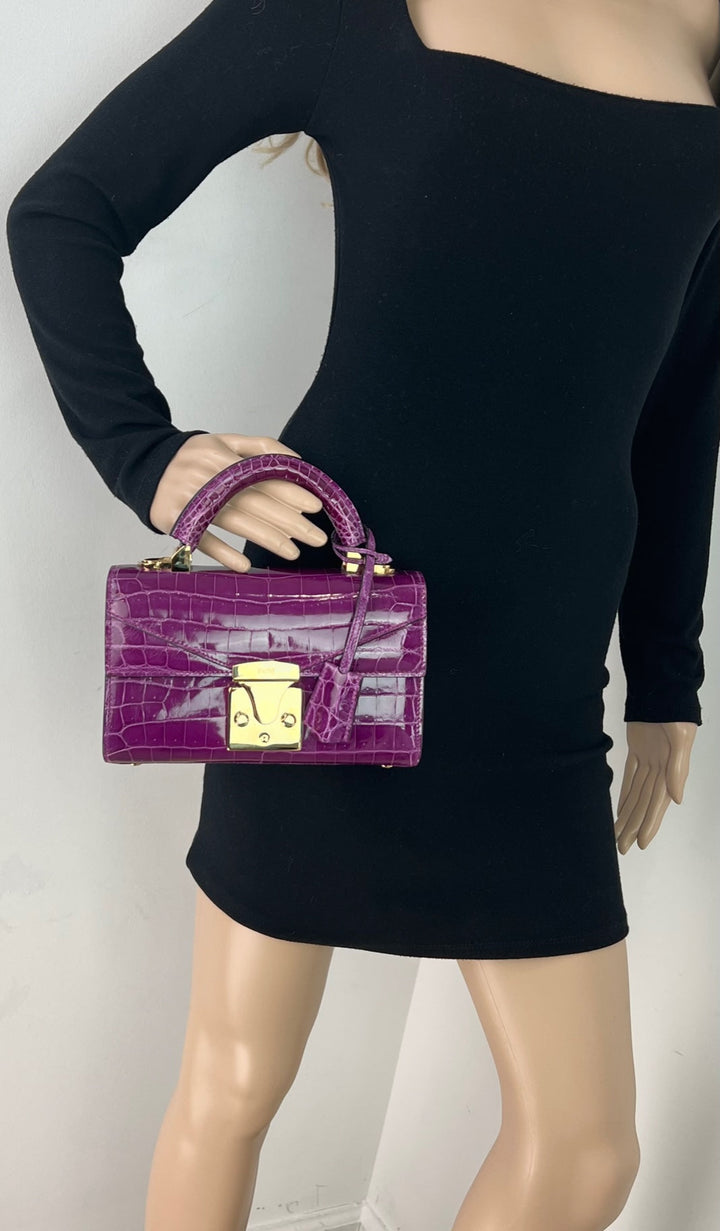 Model showcasing Exclusive Stalvey Top Handle 2.0 Alligator Bag Crossbody Luxury Bag in vibrant purple.