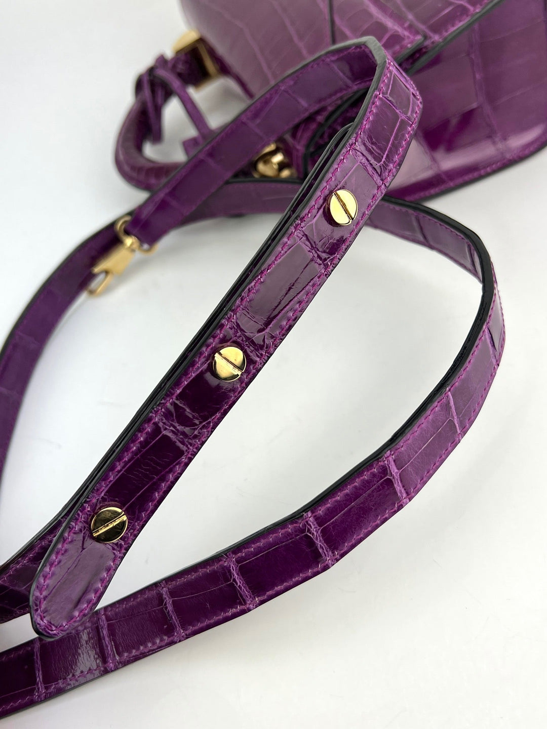 Exclusive Stalvey Top Handle 2.0 Alligator Bag Crossbody Luxury Bag strap detail in vibrant purple with golden hardware.