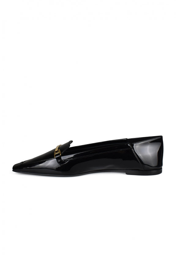 Black patent leather loafer with a gold buckle on a white background