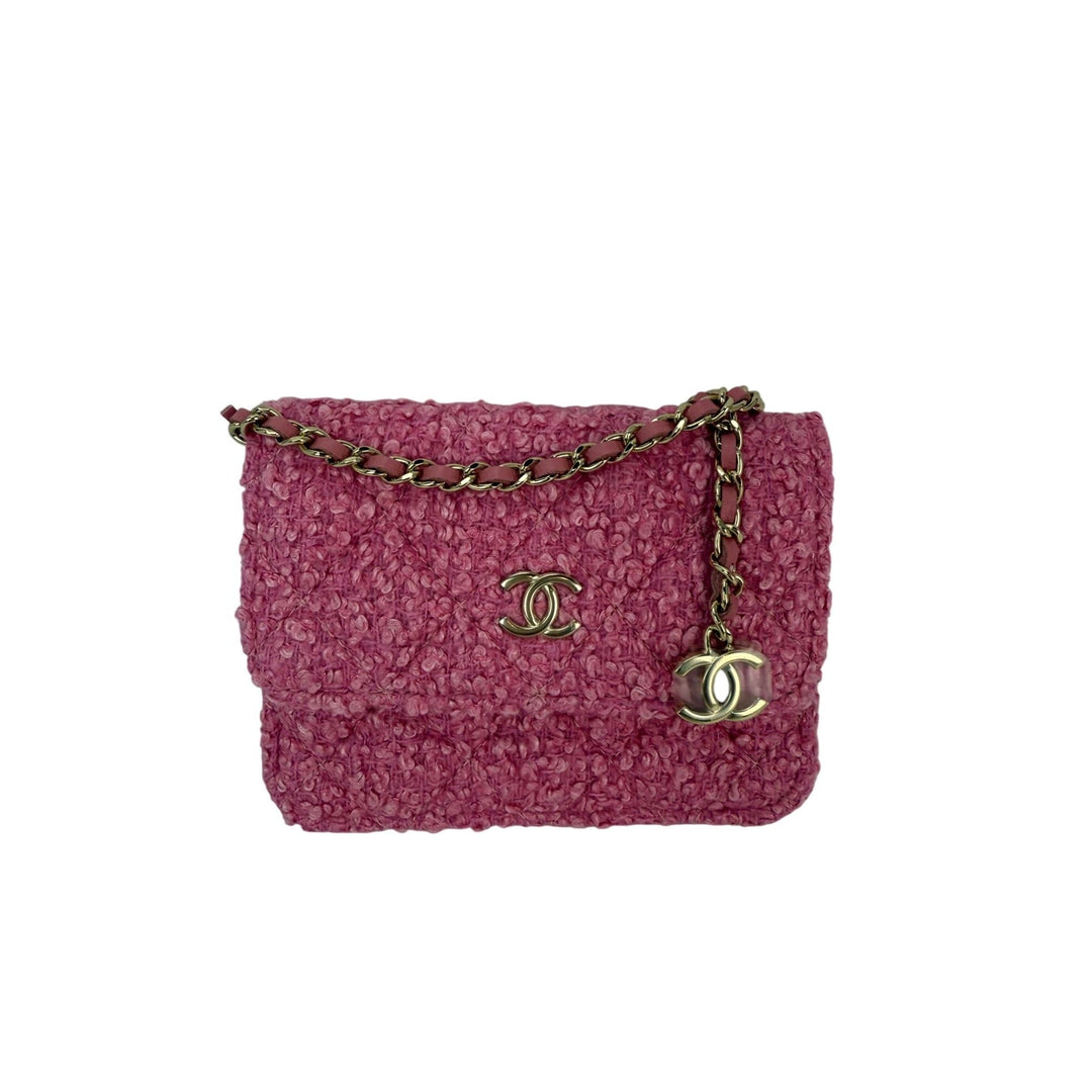 Pink textured handbag with gold chain and CC logo on a white background
