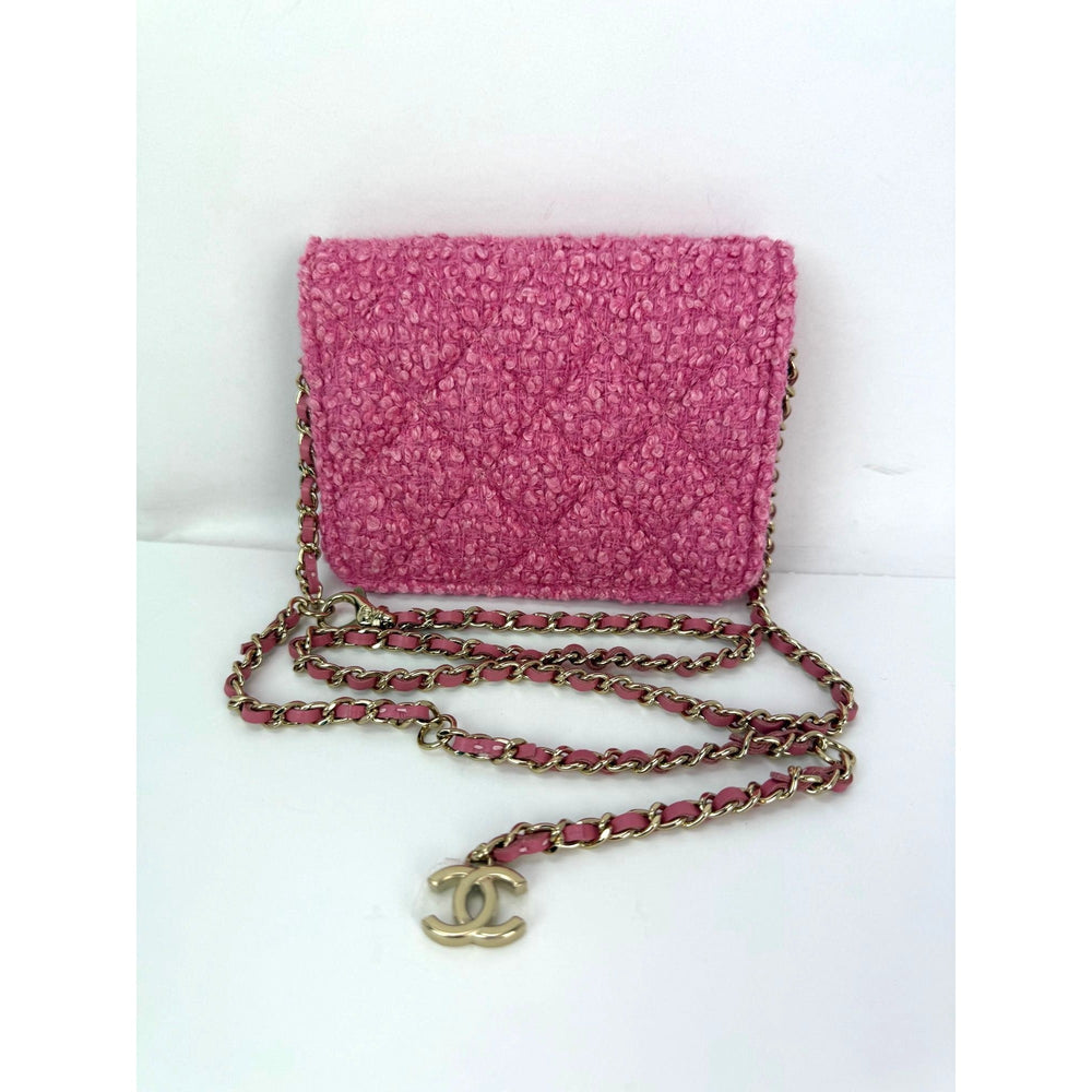 Pink textured handbag with gold chain and CC logo on a white background
