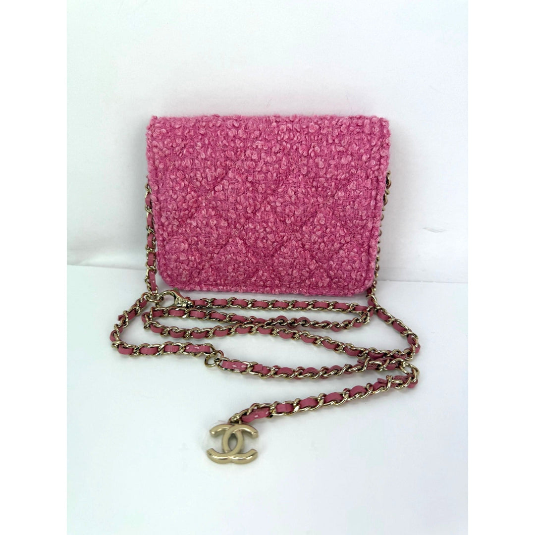 Pink textured handbag with gold chain and CC logo on a white background