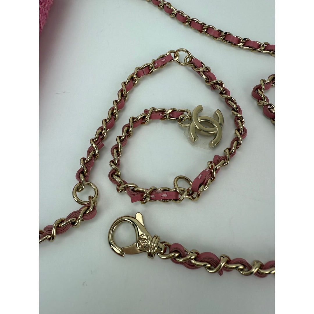 Pink and gold chain belt with a clasp on a white background
