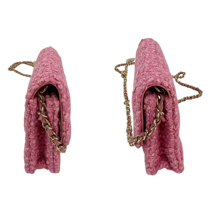 Pink textured handbag with gold chain strap on a white background