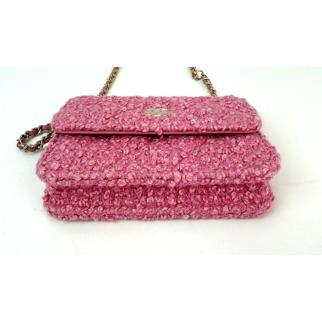 Pink textured handbag with a chain strap on a white background