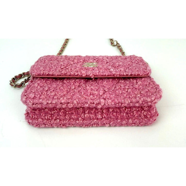 Pink textured handbag with a chain strap on a white background