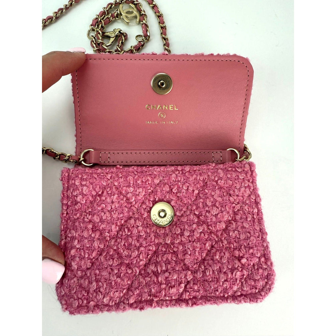 Pink Chanel handbag with textured front and gold chain strap on a white background