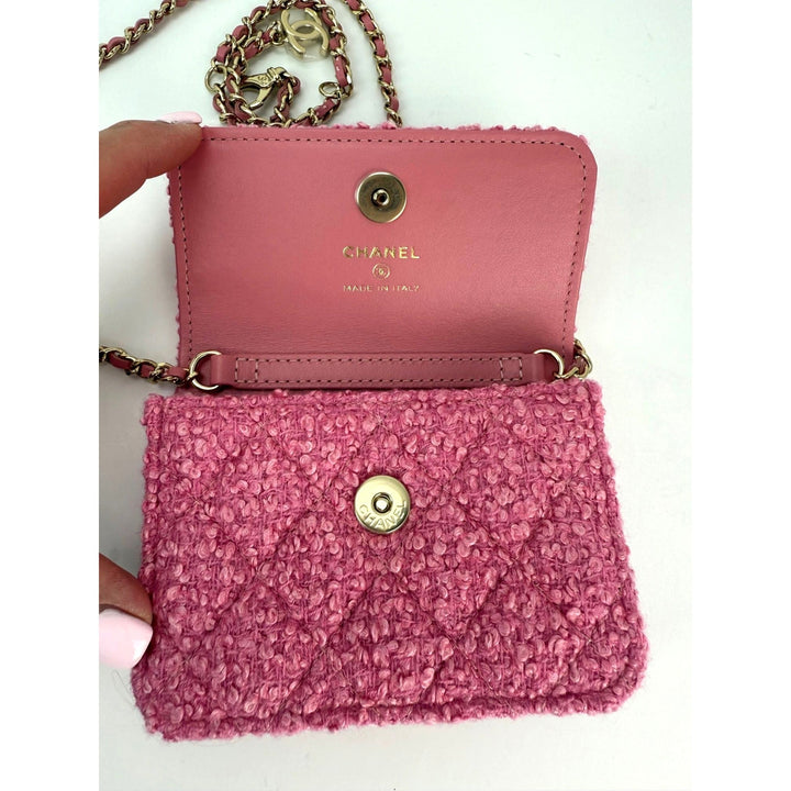 Pink Chanel handbag with textured front and gold chain strap on a white background