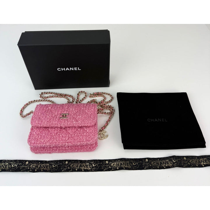 Pink Chanel handbag with chain strap, black box, and dust bag on a white background