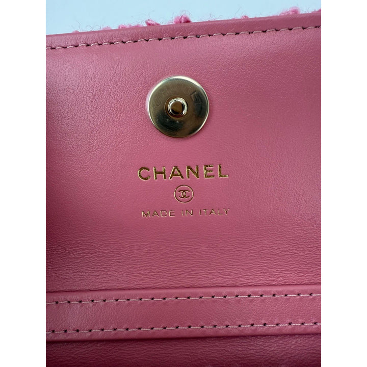Close-up of a pink Chanel handbag with gold logo and 'Made in Italy' text.