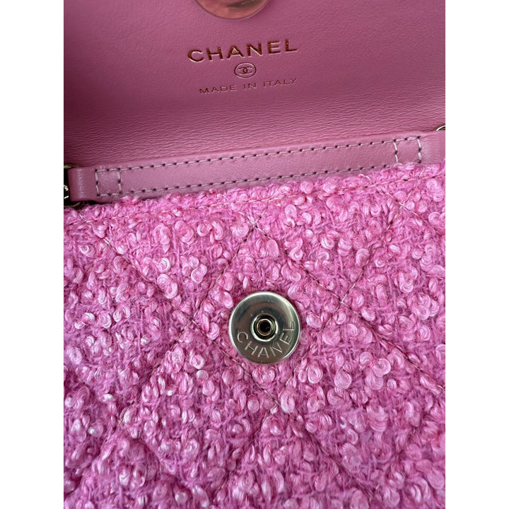 Close-up of a pink Chanel handbag with textured surface and logo.