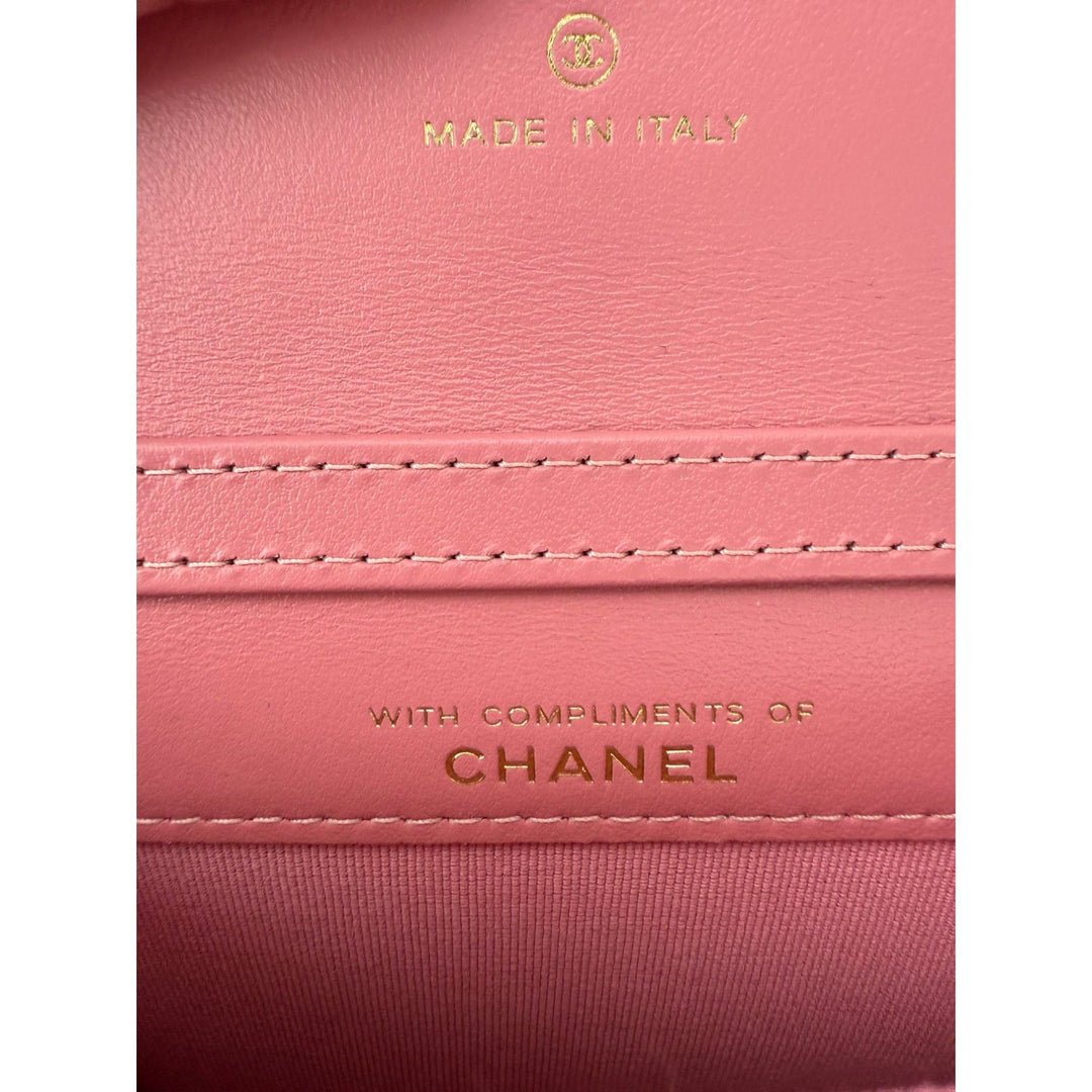 Close-up of a pink Chanel wallet with 'Made in Italy' and 'Chanel' branding.