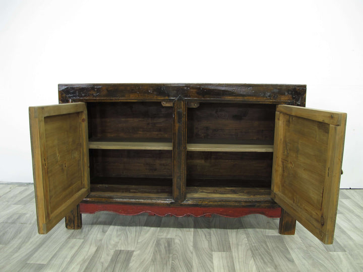 Wooden cabinet with open doors on a gray floor and white wall background