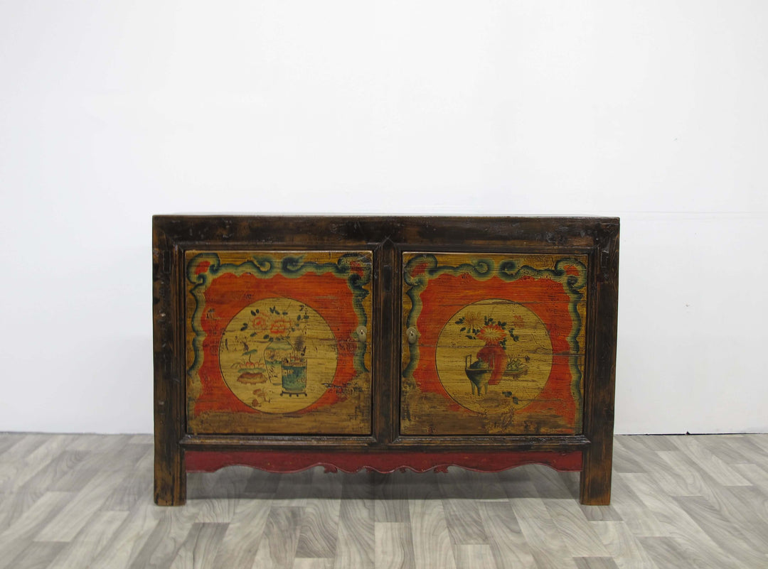Vintage wooden cabinet with colorful artwork on a white background