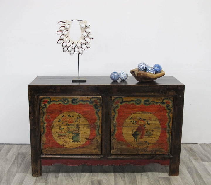 Wooden cabinet with decorative doors featuring animal illustrations, placed on a light wooden floor against a white wall.