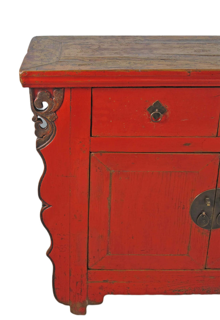 Red wooden cabinet with a single drawer and decorative carvings on a white background