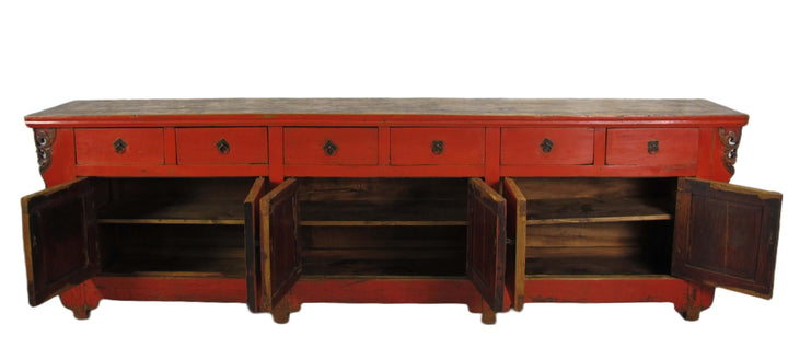 Red wooden sideboard with open doors on a white background