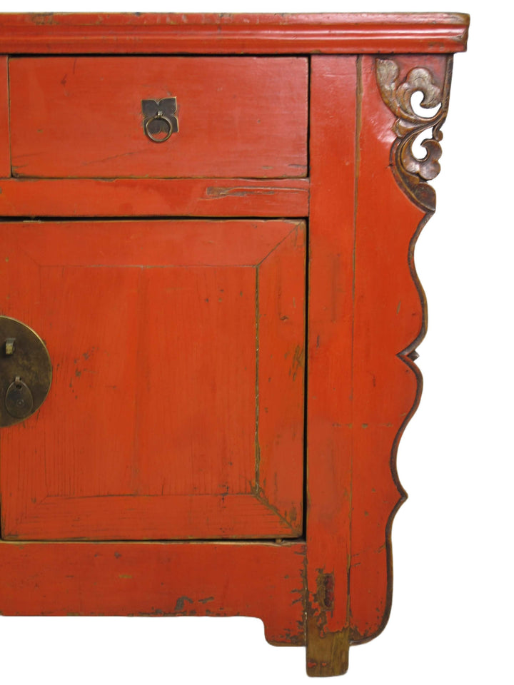 Red wooden cabinet with intricate carvings on a white background