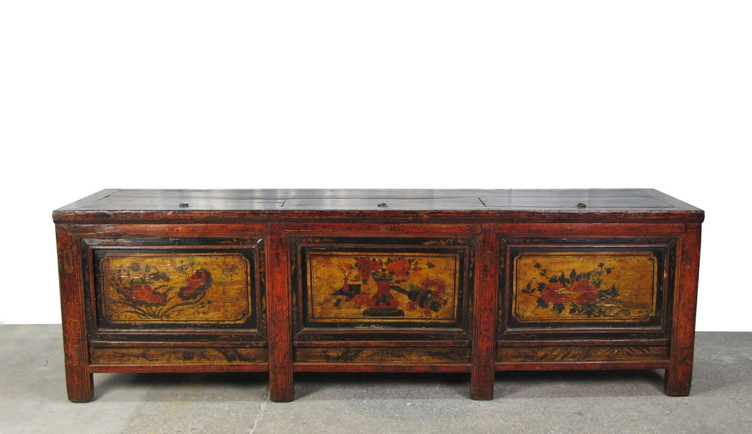 Vintage wooden sideboard with floral and bird designs on a white background