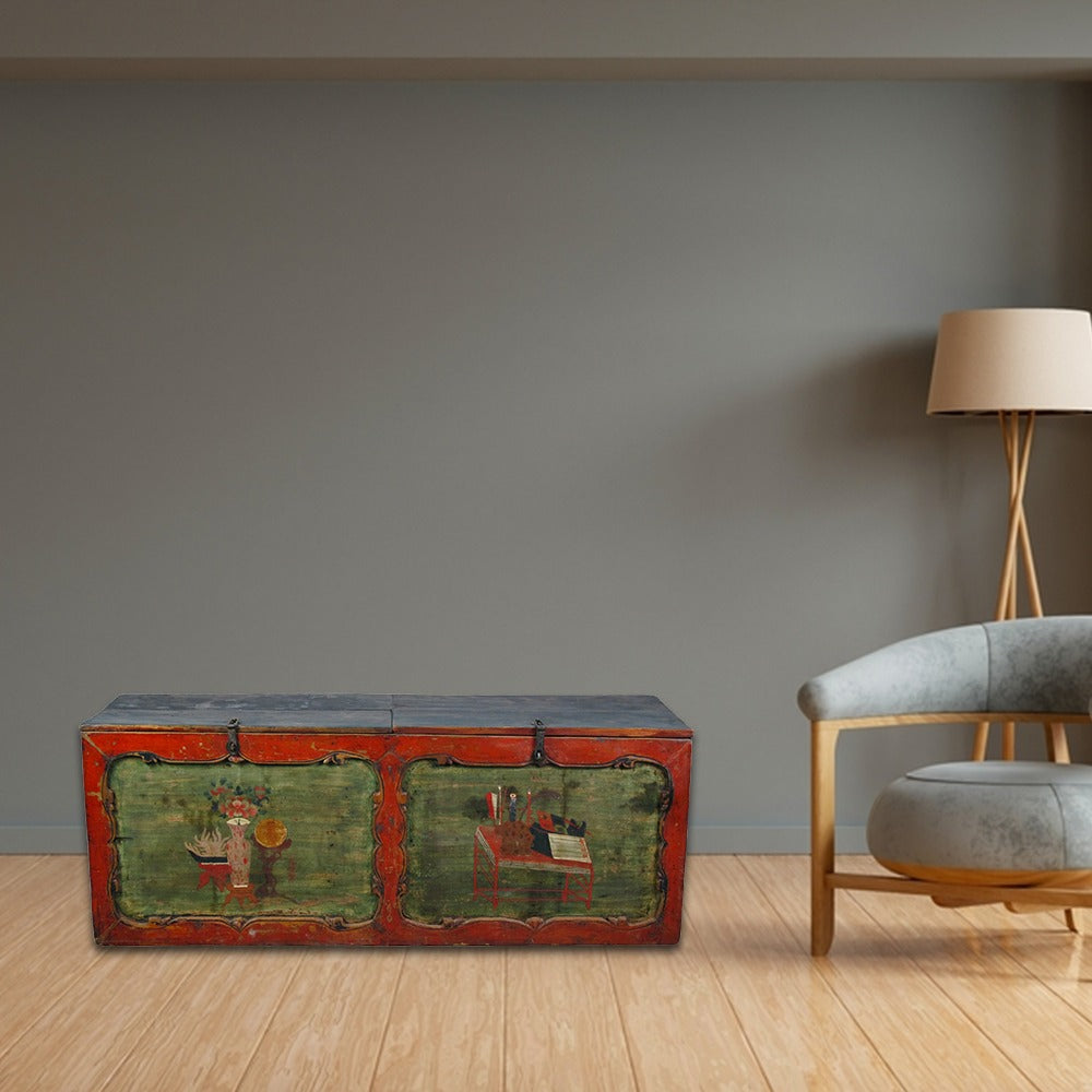 Vintage trunk with green and red paint in a modern room with a gray wall and wooden floor.