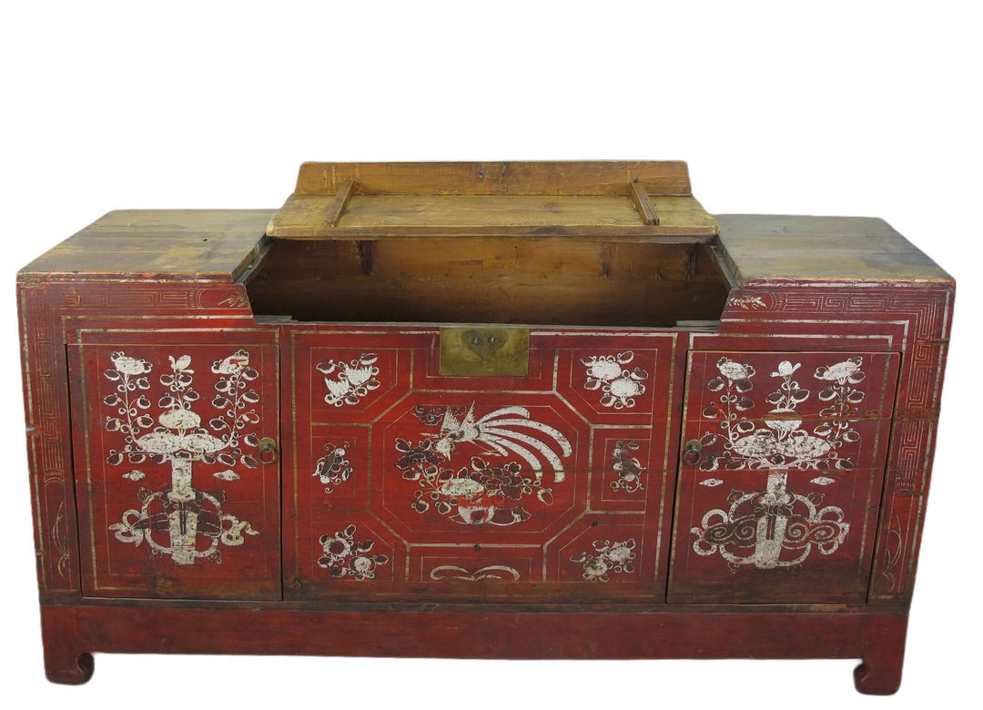 Red wooden chest with intricate white designs on a white background