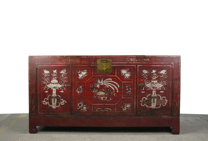 Red wooden chest with intricate carvings on a white background
