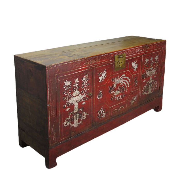 Decorative red wooden trunk with intricate white designs on a white background