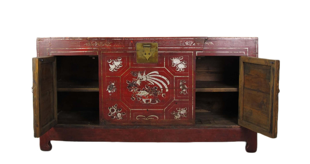 Vintage red wooden cabinet with intricate designs on a white background