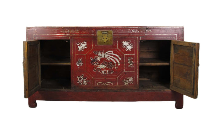 Vintage red wooden cabinet with intricate designs on a white background
