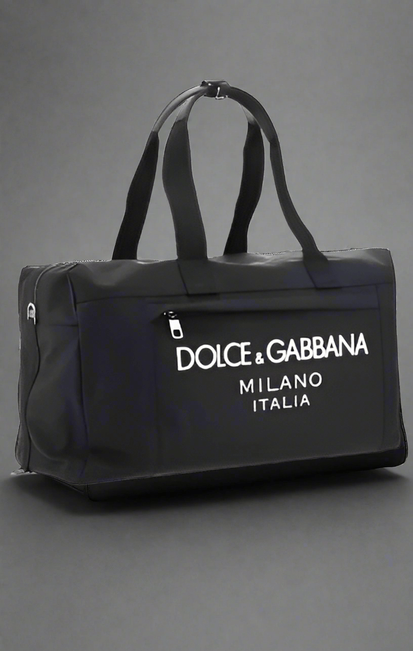 Travel Bag by Dolce&Gabbana, top closure with double-slider zipper, zippered welt pocket on back, iconic brand monogram printed in contrast on front, patch pocket on front panel, removable and adjustable nylon shoulder strap.

