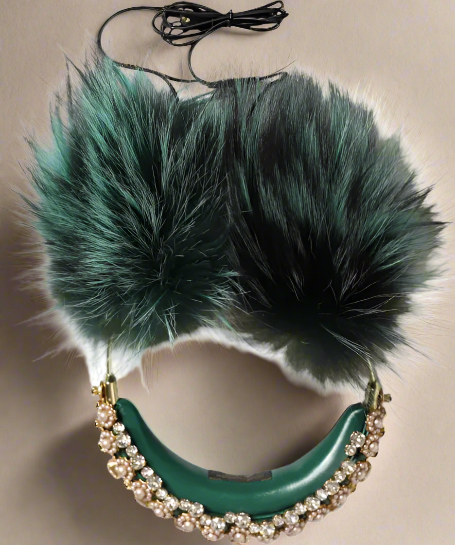 Green necklace with large fur pom-poms on a white background