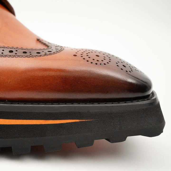 Thick-soled calfskin formal brogue derby shoes Brown close-up view highlighting the brogue detailing and squared toe.