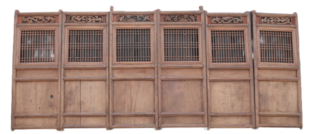 Wooden panel with intricate carvings on a plain background