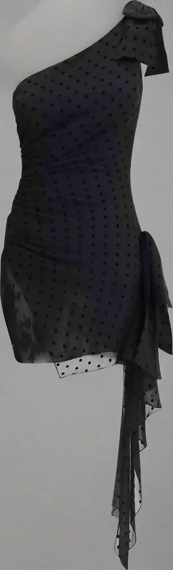 Black polka dot one-shoulder dress with ruffled details on a white background