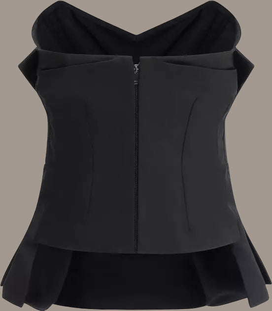 Black sleeveless top with ruffled details on a white background