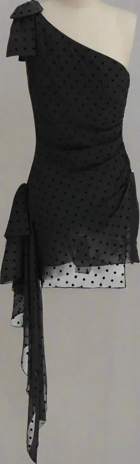 Black one-shoulder dress with white polka dots on a white background